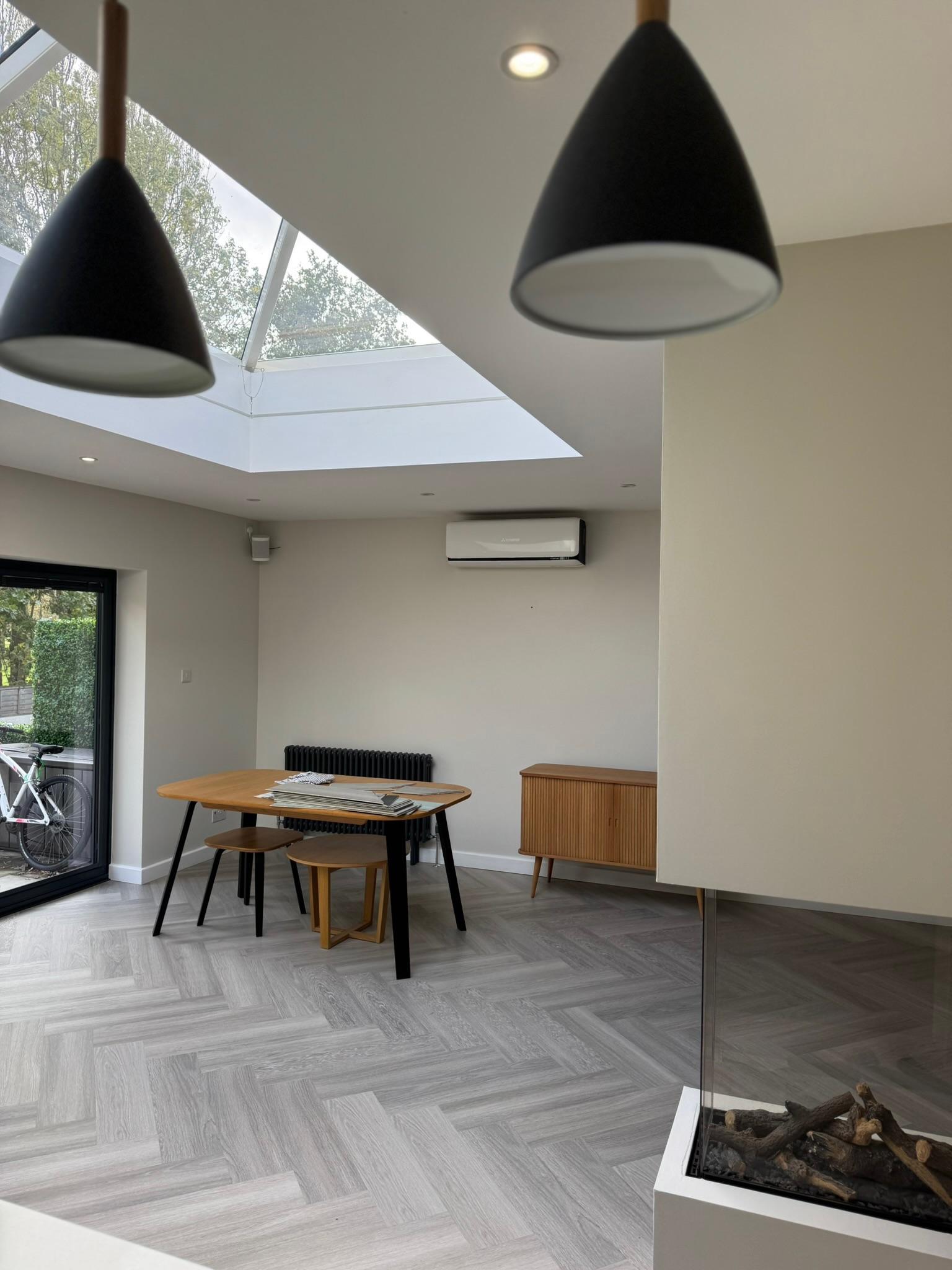 Modern dining area with pendant lights and glass fireplace