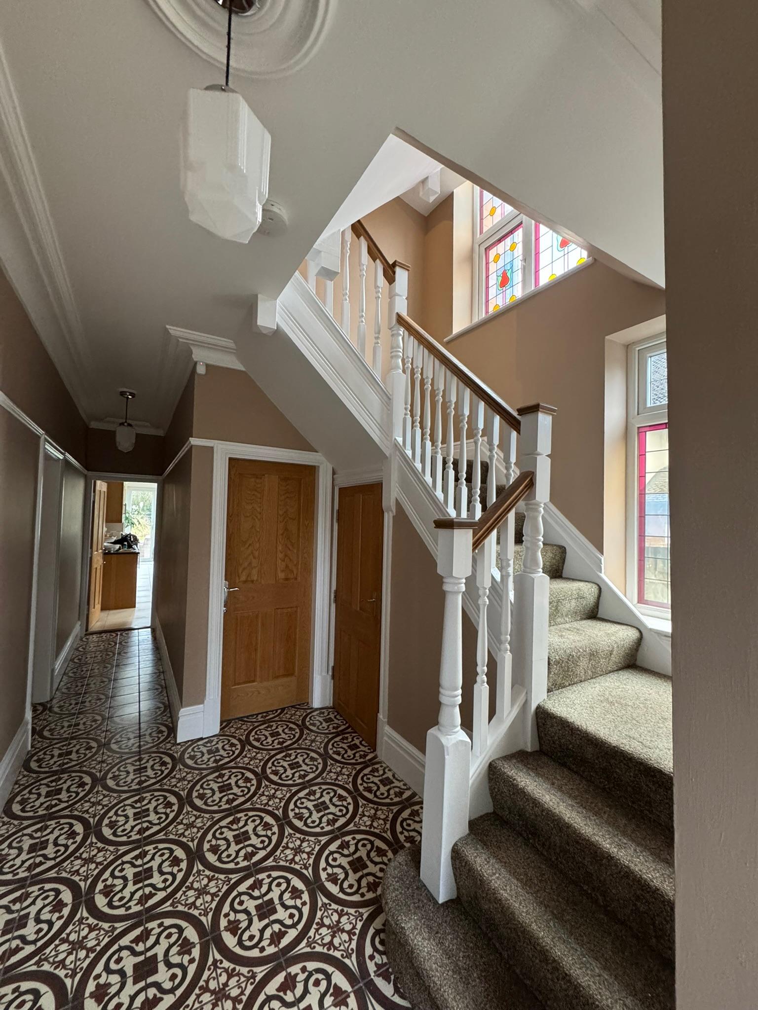 Victorian hallway with stained glass and decorative tiled floor